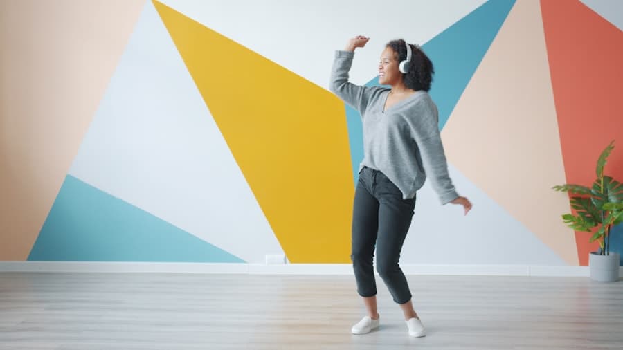 A creator dancing joyfully with headphones on in front of a colorful wall
